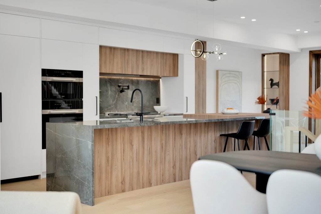 Custom kitchen cabinetry with natural wood oak island and integrated appliances in Toronto home by Forma Fine Cabinetry