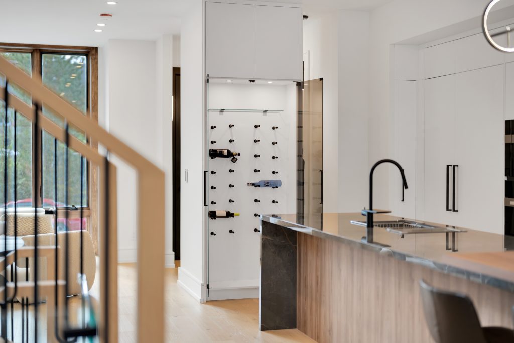 Custom built-in wine rack with integrated cabinetry and kitchen island in Toronto home by Forma Fine Cabinetry
